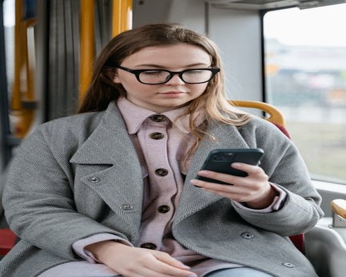 Person holding a phone while sitting on a city bus