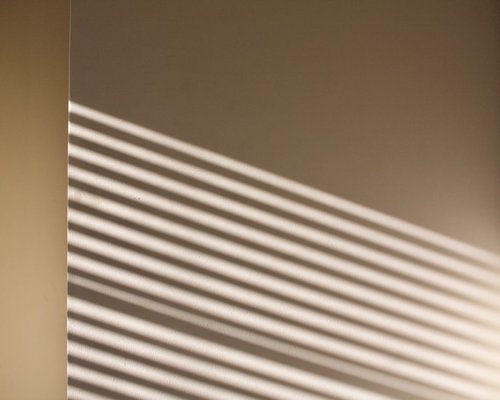 Abstract shadows from a window blind on a wall